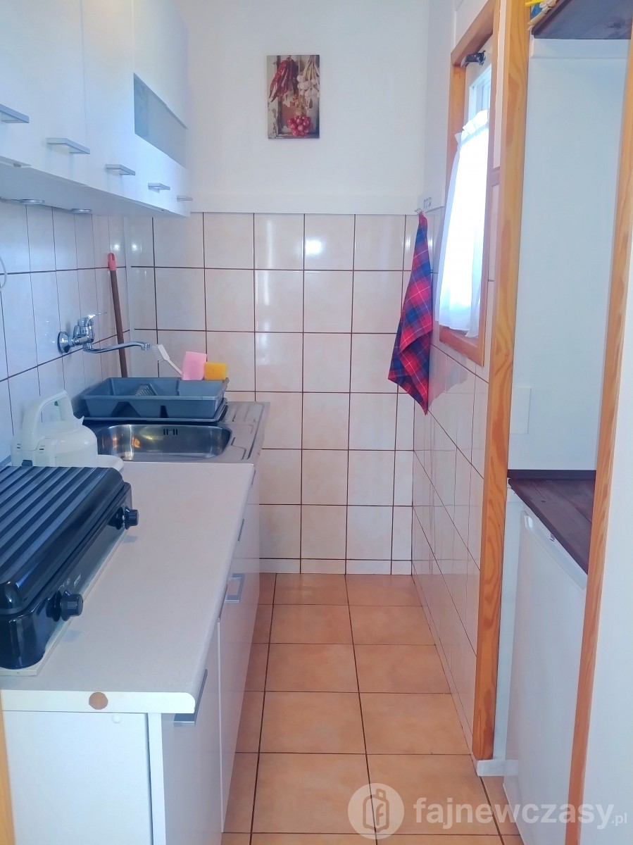 Oddzielna kuchnia w domku z kuchenką gazową i zlewem