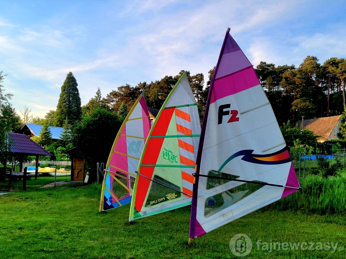 Kolorowe żagle windsurfingowe ustawione na trawie